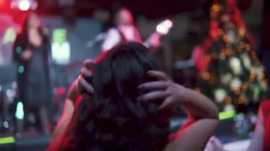 çok renkli lambalar ışınlarının bir konserde dans genç çekici kadın. Arkadan görünüm