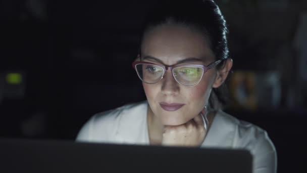 Επιχειρήσεων γυναίκα που εργάζεται στο γραφείο αργά το βράδυ. αντανάκλαση από την οθόνη του υπολογιστή με τα γυαλιά. — Αρχείο Βίντεο