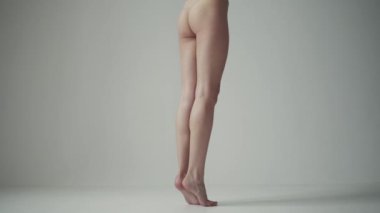 güzel ince kadın bacaklar. Arkadan görünüm. Kız uçlarında duran ve ayak ayak kayması.