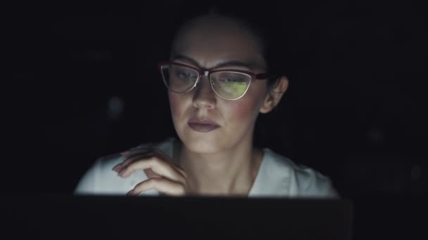 Αντανάκλαση από την οθόνη με τα γυαλιά. Πορτρέτο μιας γυναίκας επιχειρήσεων που εργάζονται αργά σε έναν φορητό υπολογιστή. — Αρχείο Βίντεο