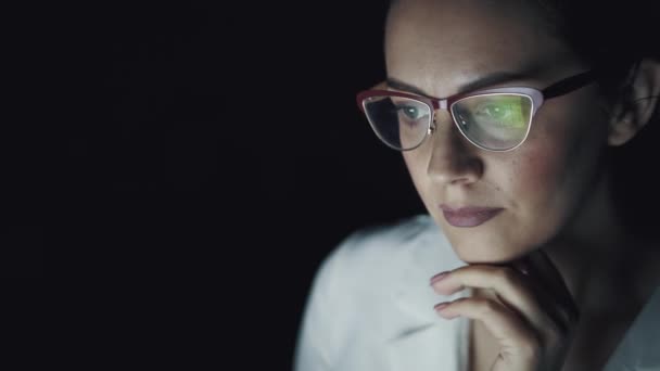 Отражение экрана в очках. Крупный план портрета деловой женщины, работающей допоздна на ноутбуке . — стоковое видео