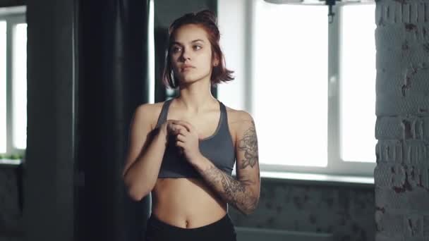 Mujer joven haciendo estiramiento en el gimnasio antes del ejercicio. chica se calienta en el fondo del anillo de boxeo — Vídeos de Stock