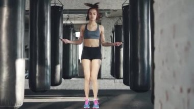 atlama ipi salonunda yumruk torbası arka plan üzerinde kız. Eğitim spor atlet.