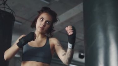 bir boksör kız closeup portresi. çekici kickboks kadın eğitim kum torbası fitness salonunda