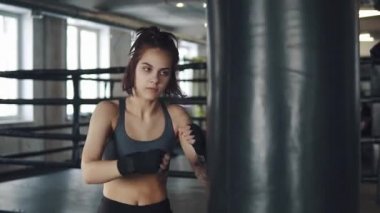 bir boksör kız closeup portresi. çekici kickboks kadın eğitim kum torbası fitness salonunda