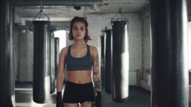 bir boksör kız closeup portresi. Boks torbası arka planı çekici kickboks kadın gider