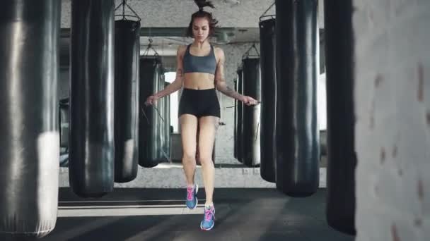 Potret seorang atlet wanita di gym. gadis muda melakukan cardio jumping tali — Stok Video