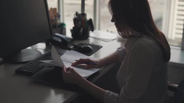 femme d'affaires travaillant dans un bureau confortable. un jeune employé travaille avec des documents lorsqu'il est assis à la table .