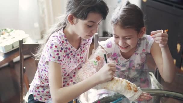 Un enfant attentionné peint d'une couleur vive une main plâtrée à sa sœur . — Video