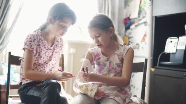 Les enfants se rassemblent sur le bras plâtré dans le pansement. sœur encourage et prend soin d'une jeune sœur malade . — Video