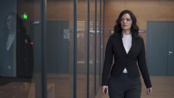 Jonge vrouw in Business Suit lopen de gang van een kantoorgebouw. — Stockvideo