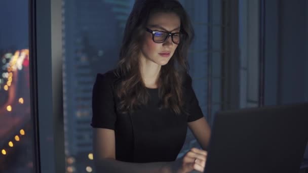 Closeup portrét obchodní ženy na pozadí nočního města. děvče pracuje pozdě v kanceláři. odraz monitoru s brýlemi — Stock video
