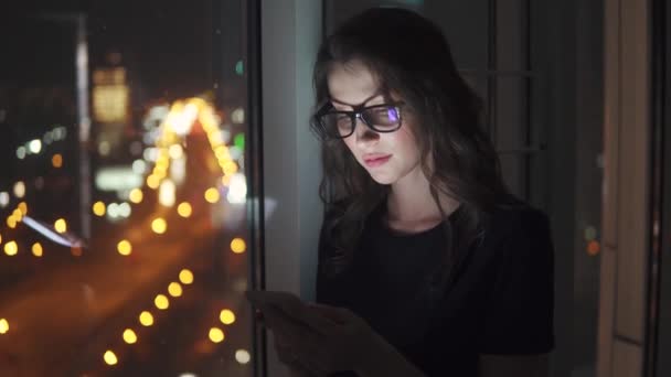 Молодая деловая женщина в свете экрана мобильного телефона. девушка со смартфоном на боке фоне ночного города . — стоковое видео