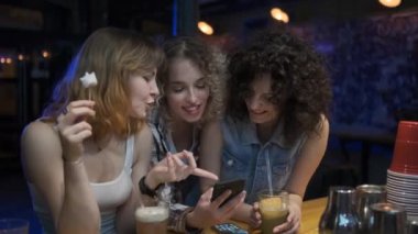 arkadaşlar bir barda oturup, gülmek ve sohbet. bir partide üç genç kadın