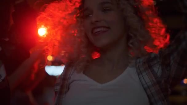 Porträtt av en attraktiv flicka på en fest i en nattklubb. flicka dansar i rampljuset. — Stockvideo