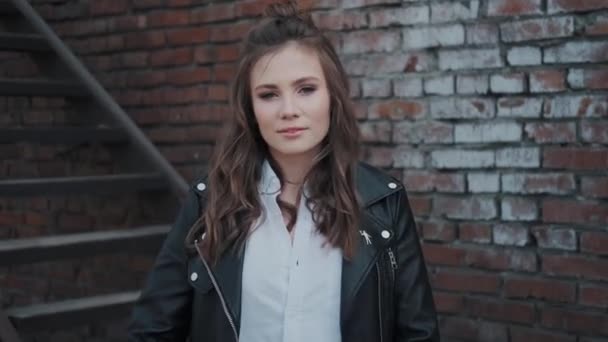 Menina hipster em uma jaqueta de couro andando pela rua . — Vídeo de Stock