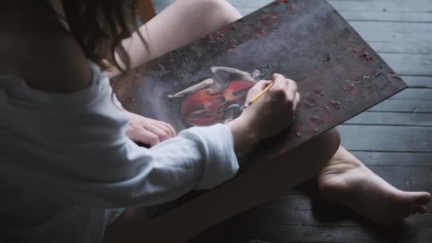 Artist paints a picture of sitting on the floor at home. top view — Stock Video