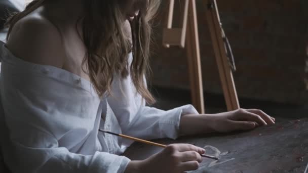 Ritratto ravvicinato dell'artista. ragazza dipinge un quadro di seduta sul pavimento . — Video Stock