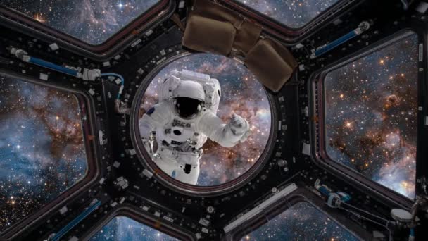 Utsikt från hyttventil Space Station. Astronaut svävar i yttre rymden mot en bakgrund av en galax och ett kluster av stjärnor. — Stockvideo