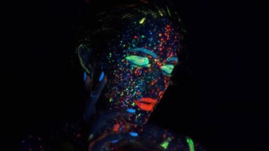 kızların yüzünde parlayan boya. Yüzünde parlayan boya ile güzel bir genç kadının portresi.