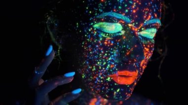 kızlar parlayan boya sıçramaları ile yüz. neon ışık genç bir kadının portresi.