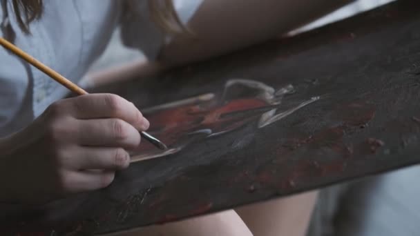 La fille artiste peint un tableau de peintures. Mains féminines gros plan — Video