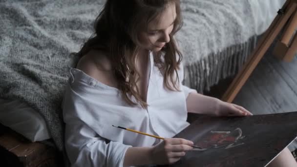 Портрет девушки-художника, работающей над картиной в домашней студии — стоковое видео