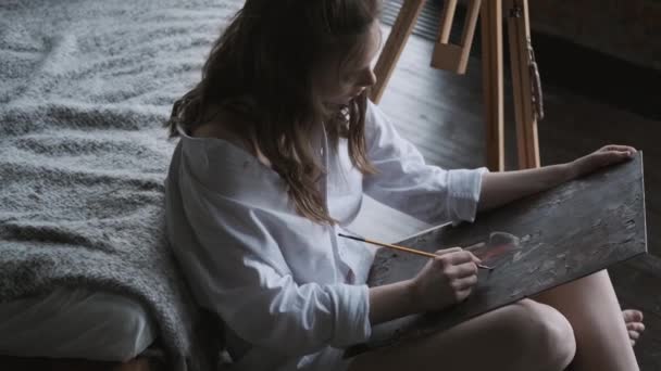 Ritratto di una ragazza artista che lavora su un dipinto in uno studio domestico — Video Stock