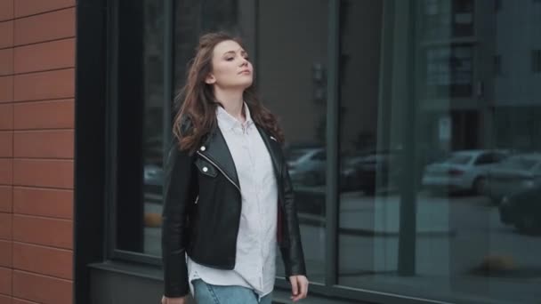 Retrato de una chica moderna caminando descuidadamente por la calle . — Vídeos de Stock