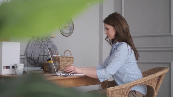 Девушка-фрилансер работает дома. молодая женщина в домашней студии работает на ноутбуке . — стоковое видео