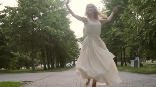 Mujer joven en un vestido que fluye bailando en la calle . — Vídeo de stock