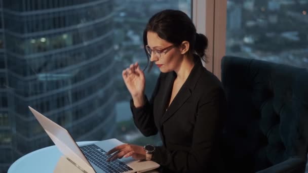 Ritratto di donna d'affari con gli occhiali in ufficio. ragazza seduta a tavola e al lavoro su un computer portatile — Video Stock