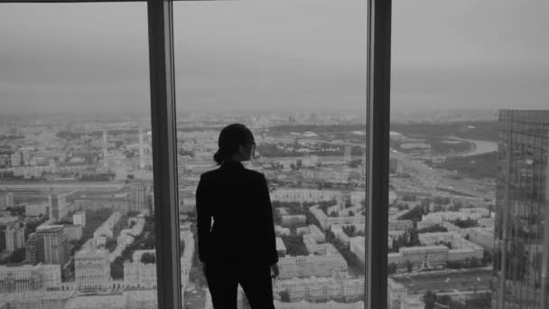 Geschäftsfrau steht in der Nähe eines großen Fensters im Hochhaus. — Stockvideo