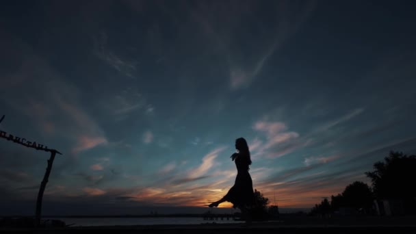 Silhouette di una ballerina danzante contro il cielo del tramonto . — Video Stock