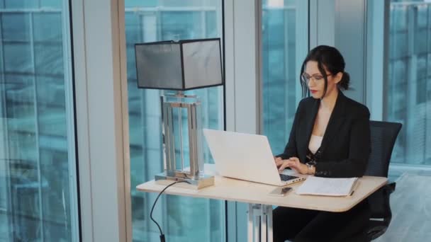 Modern bir ofiste masada çalışan iş kadını portresi — Stok video