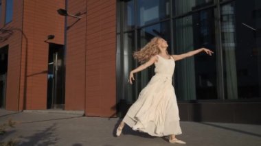 modern bir binanın arka planında dans uzun bir elbise sevimli kız