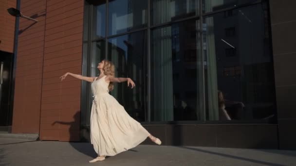 Menina em um vestido leve dançando ao ar livre. Bailarina está girando na ponta dos pés e pulando alto — Vídeo de Stock