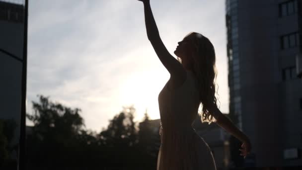 Σιλουέτα ενός ελκυστικού κοριτσιού που χορεύει σε εξωτερικούς χώρους στην πόλη — Αρχείο Βίντεο