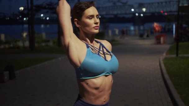 Stretching before training. young slim woman warms up before evening workout — Stock Video