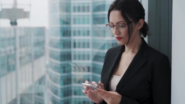 Retrato de una mujer de negocios con gafas usando teléfono móvil . — Vídeos de Stock