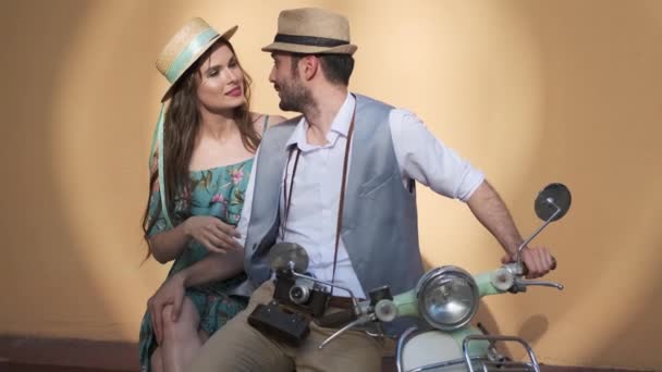 Kille och flicka sitter på en Vintage Scooter. par i kärlek vidrör försiktigt varandra. — Stockvideo