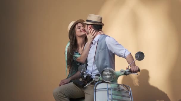 Man and a young woman are sitting on a vintage scooter. couple in love gently touch each other. — Stock Video