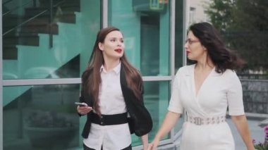 iki iş kadını yolda konuşuyor. genç çekici kadın sokakta yürürken