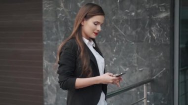 bir ceket iş kadın Smartphone bir mesaj gönderir. elinde bir cep telefonu ile genç bir kadının portre