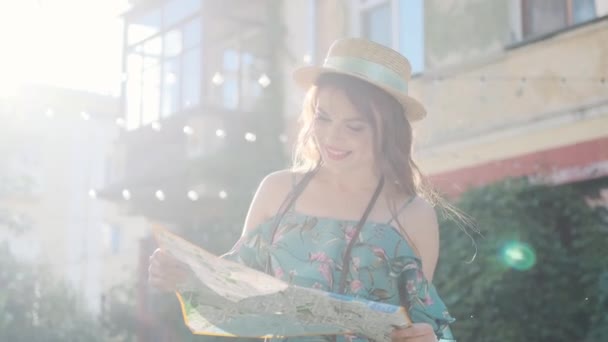 Girl traveler sits on the steps and looks at the map. portrait of a young woman tourist — Stock Video