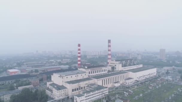 Edificios industriales con tuberías y la ciudad envuelta en humo. contaminación atmosférica y problemas medioambientales . — Vídeo de stock