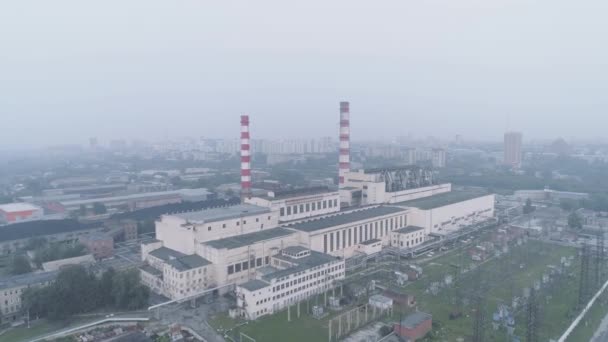 Elektriciteitscentrale met leidingen en de stad gehuld in rook. luchtverontreiniging en milieuproblemen. — Stockvideo