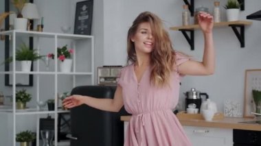 Çekici kız sabah mutfakta dans ediyor.