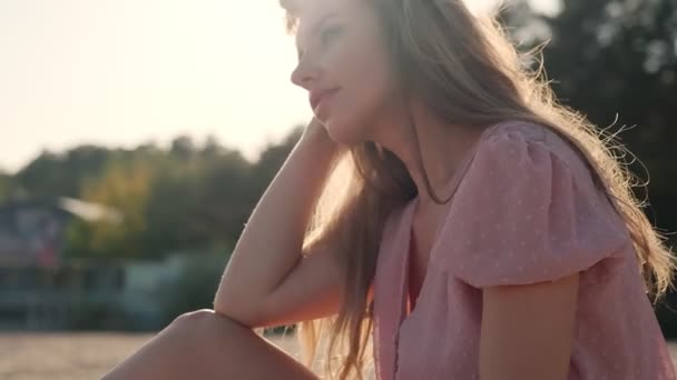 Primo piano ritratto di una ragazza carina nei raggi del sole al tramonto — Video Stock