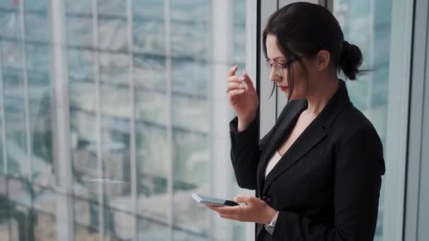 Portrait of a business man by the large window against the backdrop of skyscrapers — Stock Video